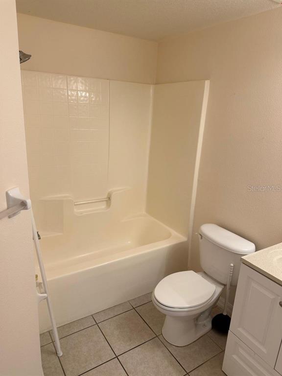 A bathroom features a white tub-shower combination, a toilet, and a vanity with tile flooring — 6425 CYPRESSDALE DRIVE UNIT 101, RIVERVIEW, FL