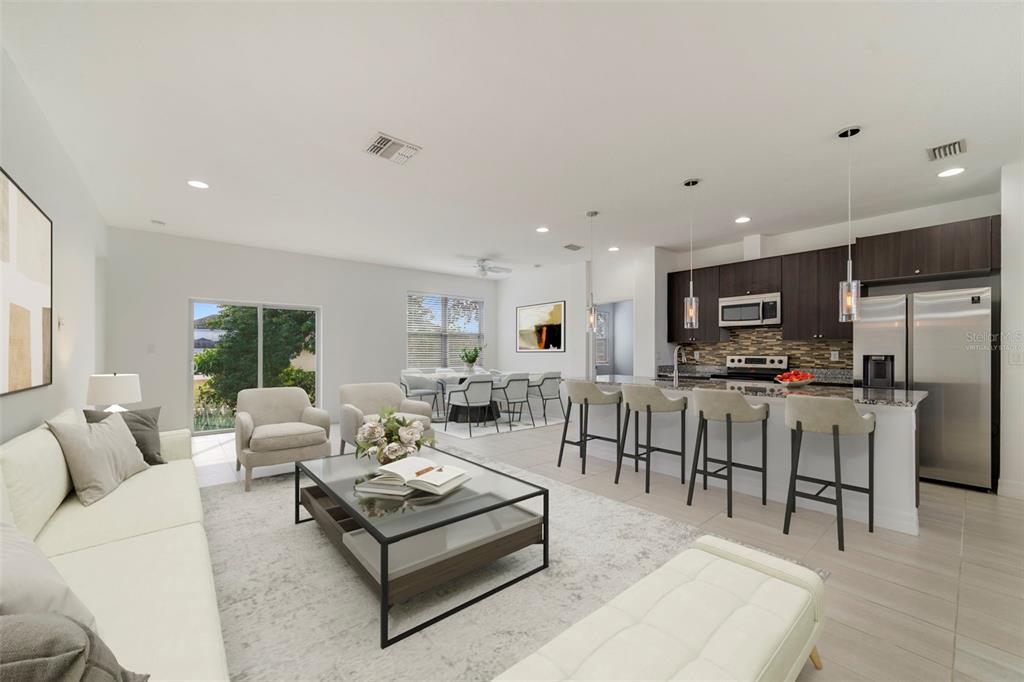 A modern open-concept living room and kitchen with dark cabinetry and a large island — 212 GROUPER COURT, POINCIANA, FL