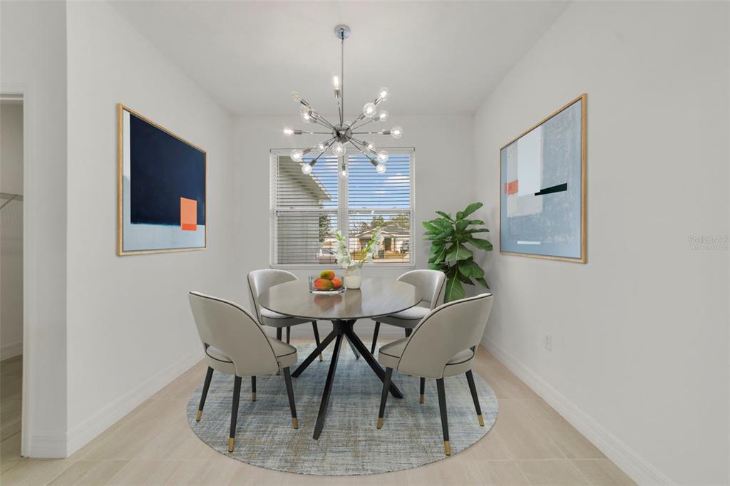 A dining room features a round table, four chairs, a chandelier, and two framed paintings — 212 GROUPER COURT, POINCIANA, FL