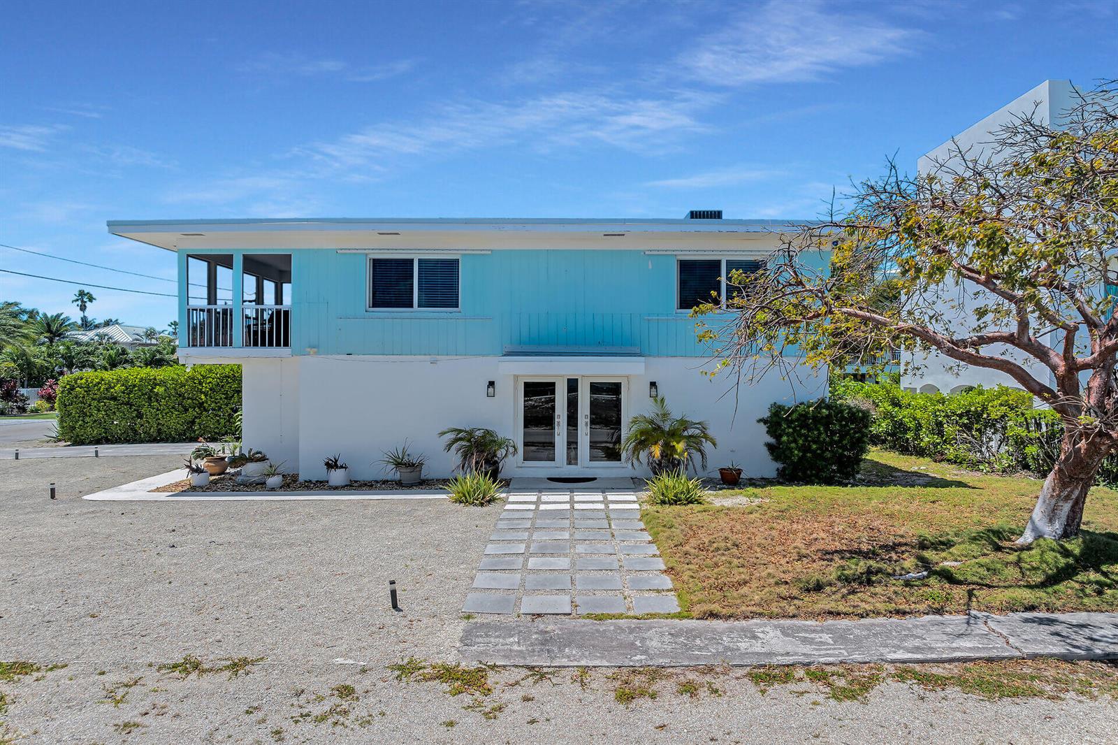 A two-story house with light blue siding, white lower walls, and a stone walkway — 309 Jasmine Street, FL 33050, FL