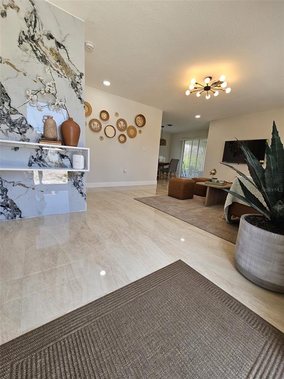A living area features a marble-accented wall, tile flooring, and a modern light fixture — 460 CREEK LANE DRIVE, ENGLEWOOD, FL