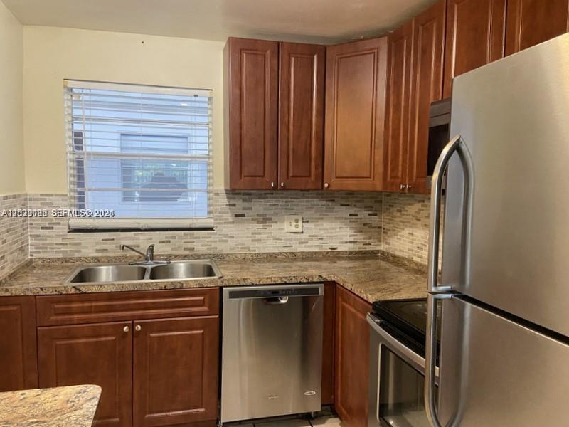A kitchen features wood cabinets, stainless steel appliances, and a tiled backsplash — 6501 Winfield Blvd # 26, Margate FL 33063, MARGATE, FL