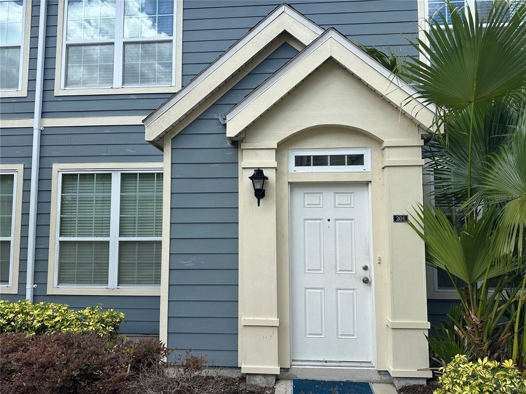 A front exterior view of a residential building with blue siding and a white door — 5601 ROSEHILL ROAD UNIT 201, SARASOTA, FL