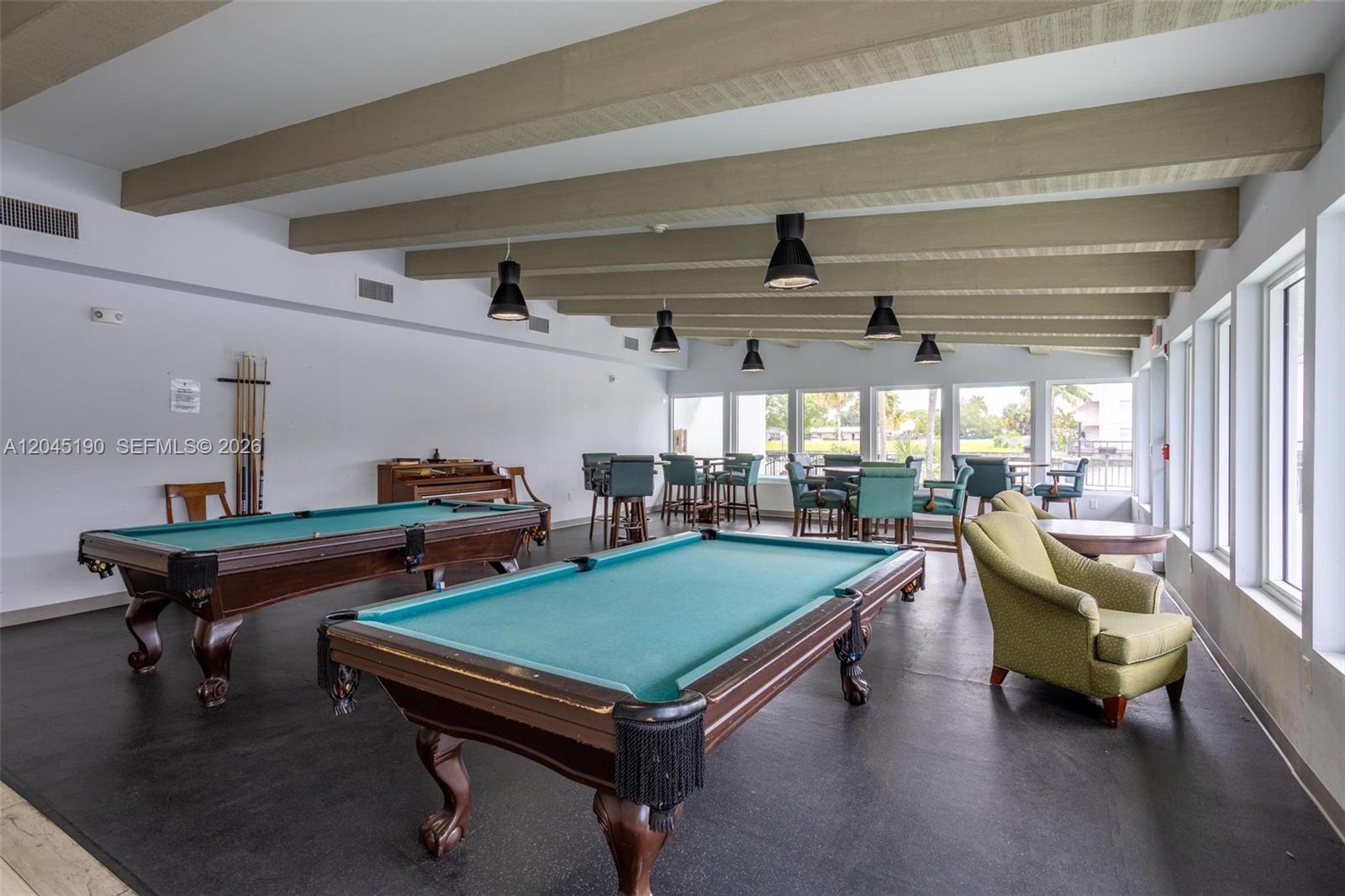A game room features two pool tables, exposed ceiling beams, and large windows — 2771 Taft St # 104, Hollywood FL 33020, HOLLYWOOD, FL