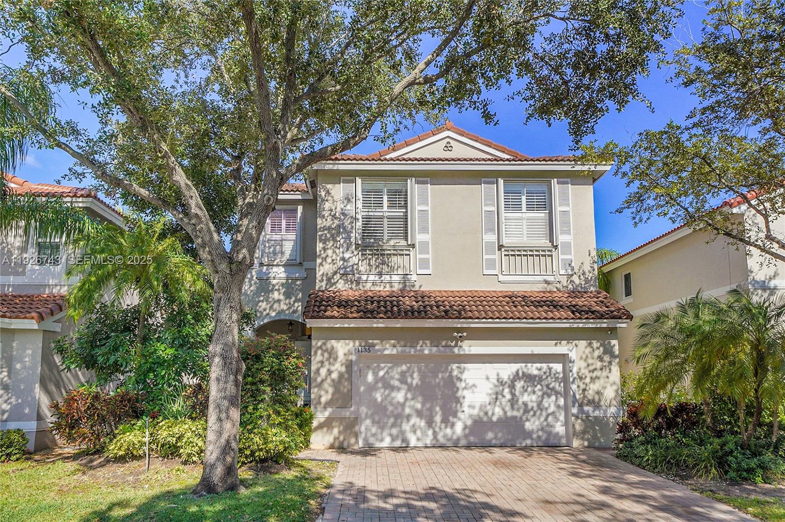A two-story house with a tiled roof, a two-car garage, and a brick driveway — 1135 Satinleaf St, Hollywood FL 33019, HOLLYWOOD, FL