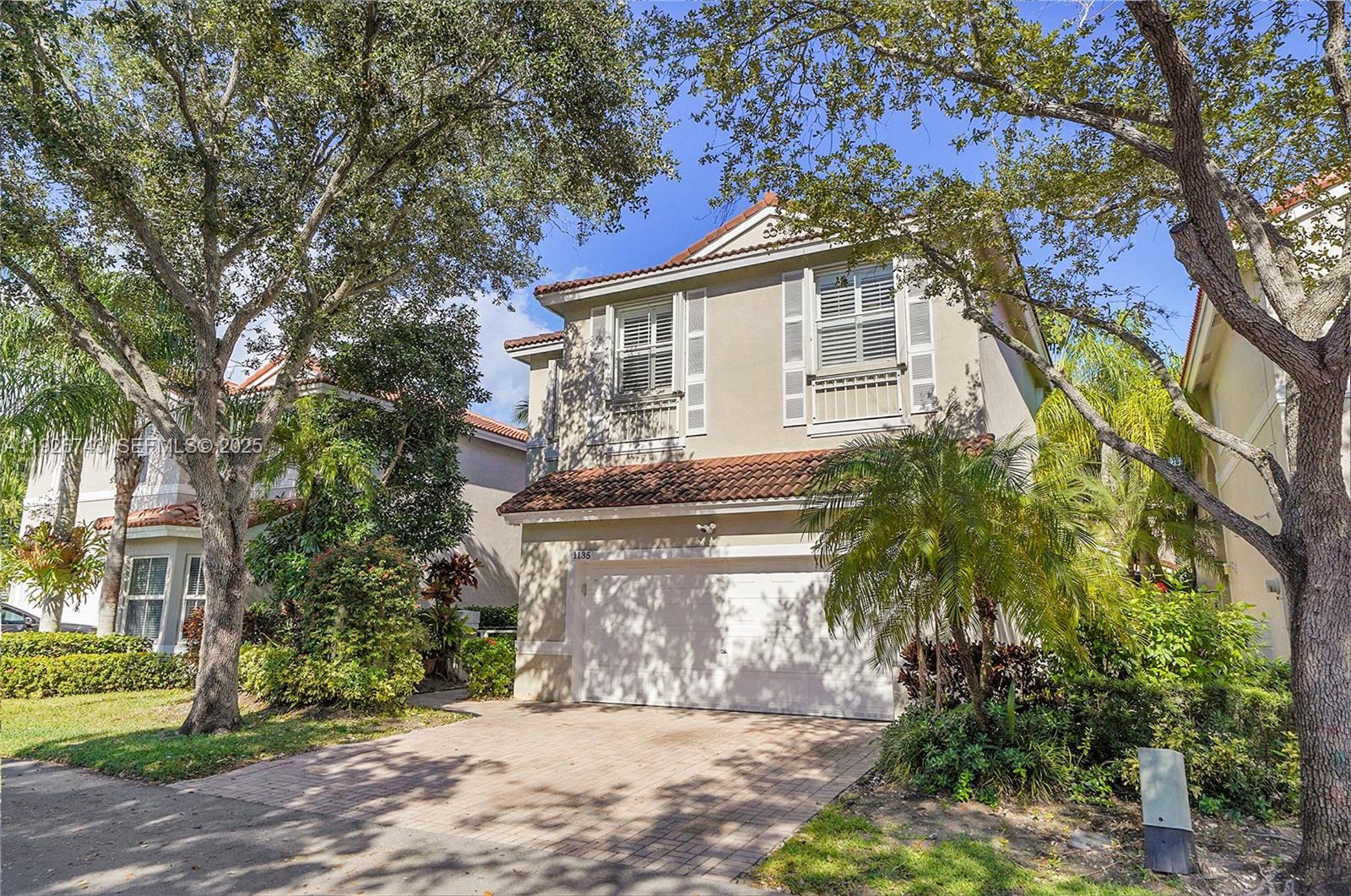 A living room features black leather sofas, a wooden floor, and a large ceiling fan — 1135 Satinleaf St, Hollywood FL 33019, HOLLYWOOD, FL
