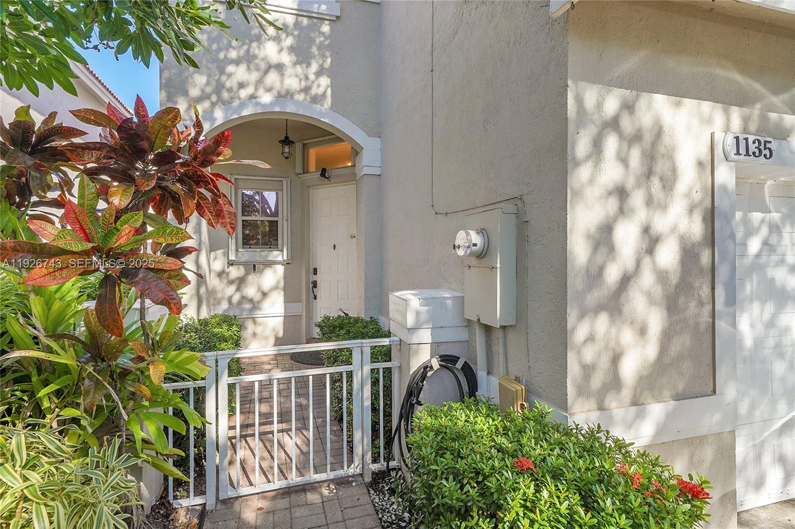 A living room with leather furniture and a staircase leads to a dining area — 1135 Satinleaf St, Hollywood FL 33019, HOLLYWOOD, FL