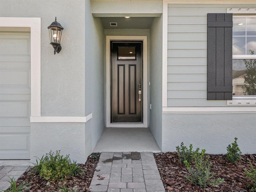 A front entrance features a black door, a light-colored stucco exterior, and a stone walkway — 13310 SHELLMORE AVENUE, PALMETTO, FL
