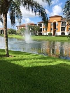 A fountain sprays water in a pond in front of multi-story apartment buildings — 8325 38TH STREET CIRCLE E UNIT 102, SARASOTA, FL