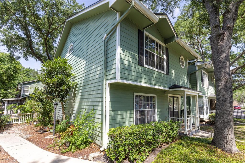 A two-story green house with white trim and a small front porch — 5990 BRAEMAR PLACE UNIT 106, ORLANDO, FL
