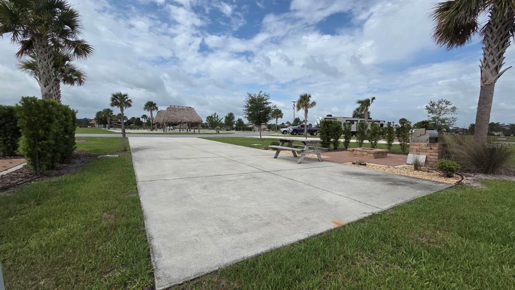 A concrete RV pad features a picnic table, a fire pit, and a grill area — 71 CEDAR CIRCLE E, LAKE WALES, FL
