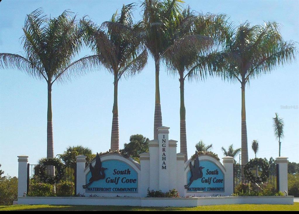 A sign for South Gulf Cove waterfront community stands beneath four tall palm trees — 14634 INGRAHAM BOULEVARD, PORT CHARLOTTE, FL