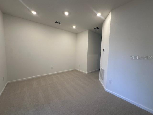 An empty room with beige carpet, white walls, and recessed ceiling lighting — 382 WOODS LANE, ST AUGUSTINE, FL