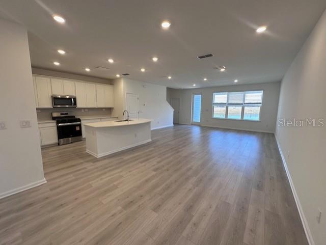 An open-concept kitchen with white cabinets and an island overlooks a spacious living area — 382 WOODS LANE, ST AUGUSTINE, FL