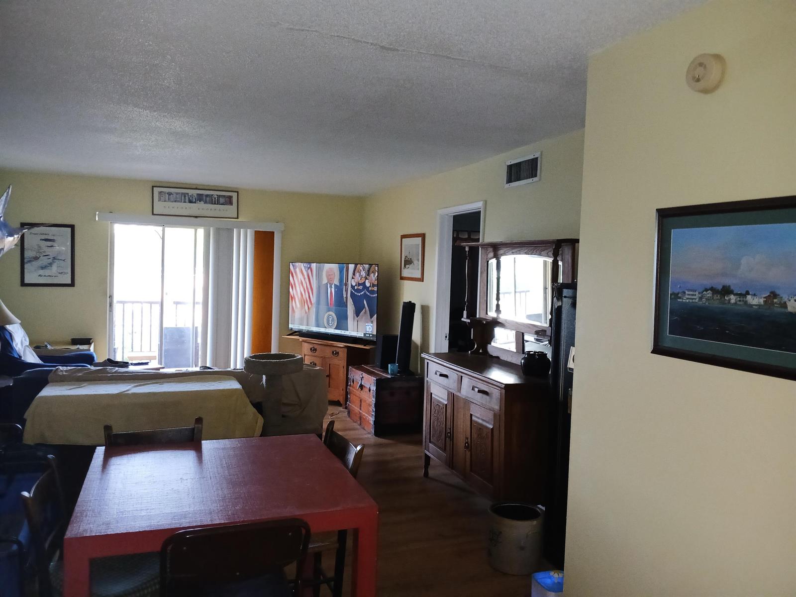 A living and dining area features a red table, wooden furniture, and a television — 2601 NE 14th St Causeway # 233, Pompano Beach FL 33062, POMPANO BEACH, FL