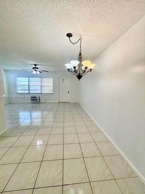 An empty room features white walls, a tiled floor, and a hanging chandelier — 202 Mansfield, Boca Raton FL 33434, BOCA RATON, FL