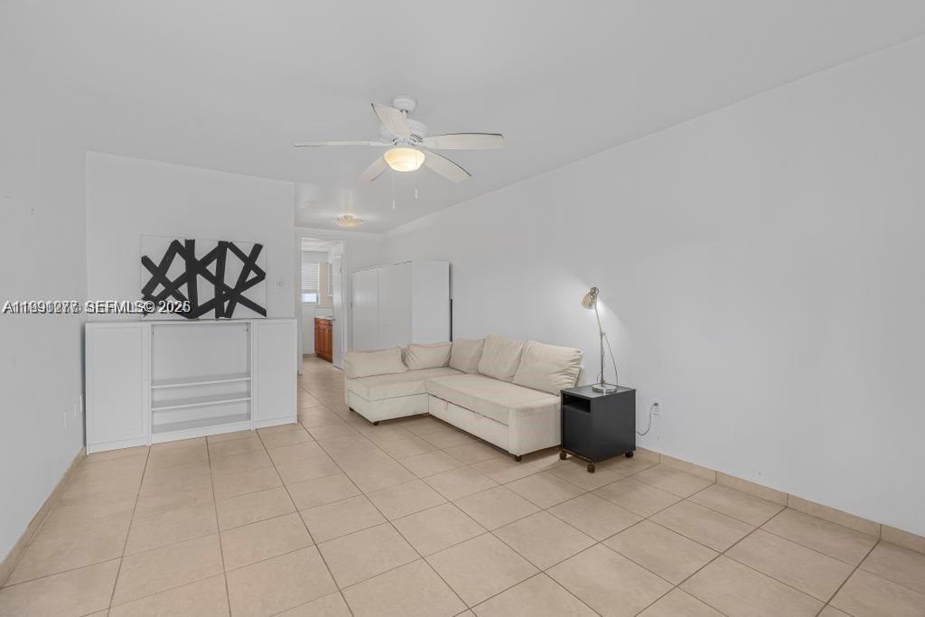 A living room features a beige sectional sofa, a white media console, and tile flooring — 200 76th St # 59, Miami Beach FL 33141, MIAMI BEACH, FL