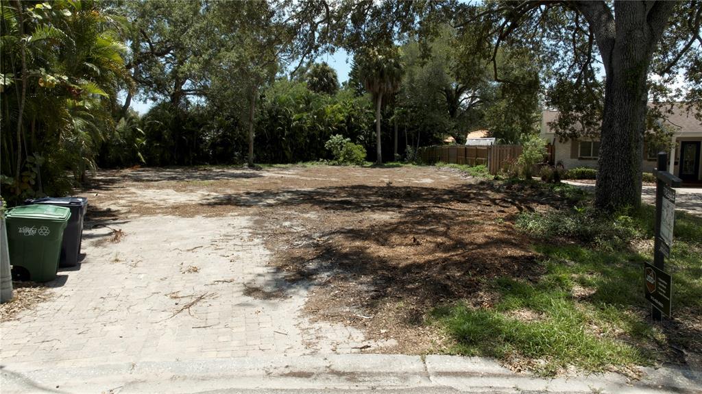 A vacant, cleared residential lot features a paved driveway section and mature trees — 2311 S LILA LANE, TAMPA, FL