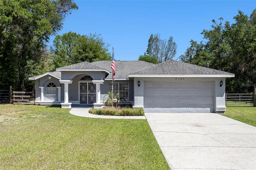 An aerial view shows a house with solar panels, a circular pool, and a wooden deck — 9105 S ZANMAR DRIVE, FLORAL CITY, FL