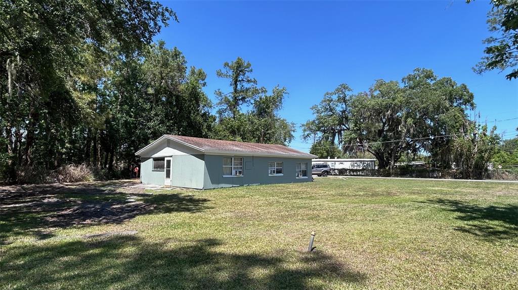 A single-story house with light green siding sits on a large, grassy lot — 4800 PETROFF AVENUE, ORLANDO, FL