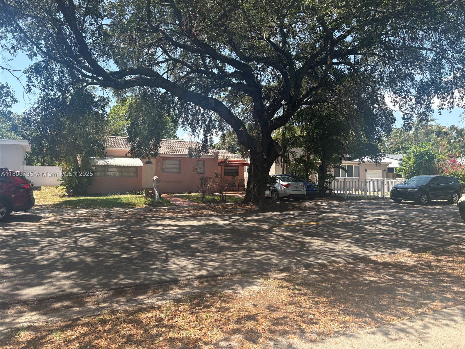 A pink single-story house sits behind a large tree with cars parked in the driveway — 2530 Washington St, Hollywood FL 33020, HOLLYWOOD, FL