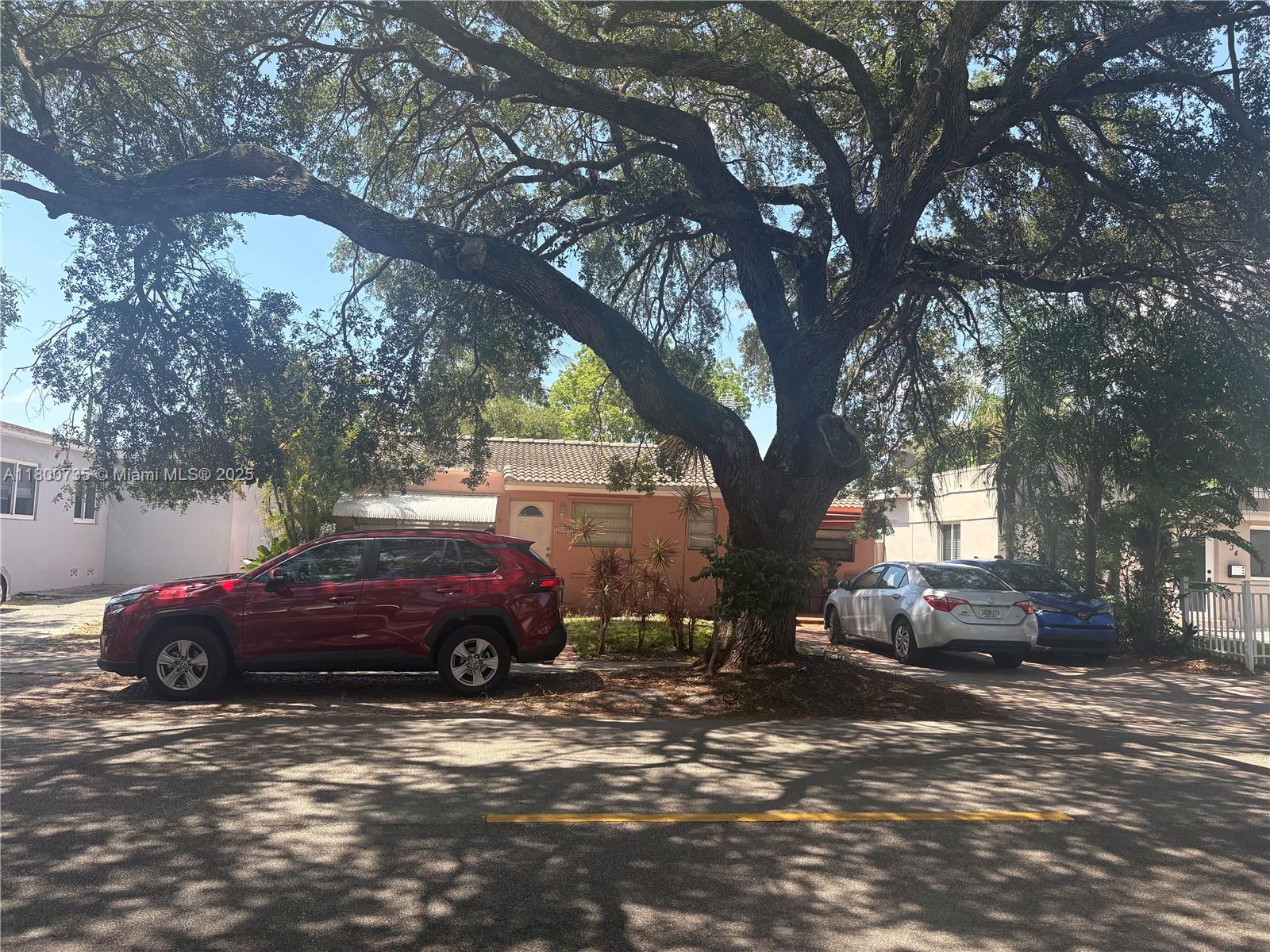 A red SUV is parked in front of a house shaded by a large tree — 2530 Washington St, Hollywood FL 33020, HOLLYWOOD, FL