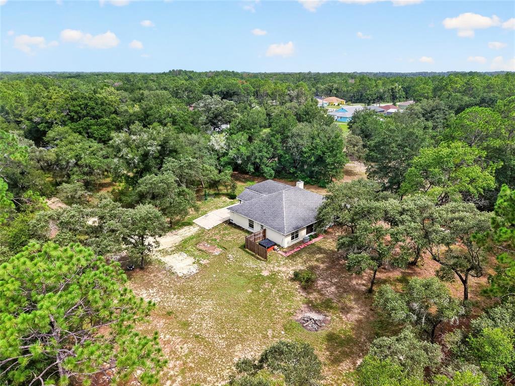 An aerial view shows a single-story house surrounded by a large, wooded lot — 7300 SW 204TH AVENUE, DUNNELLON, FL