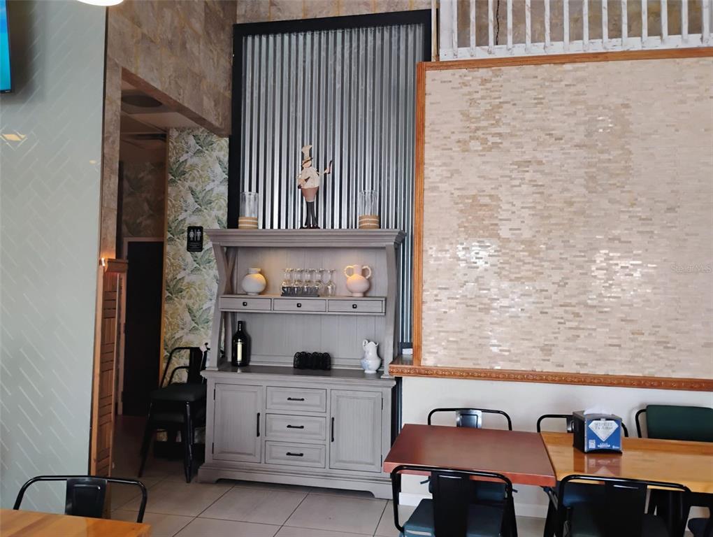 A dining area features a gray hutch, a corrugated metal wall, and tiled walls — 8001 S ORANGE BLOSSOM TRAIL, ORLANDO, FL