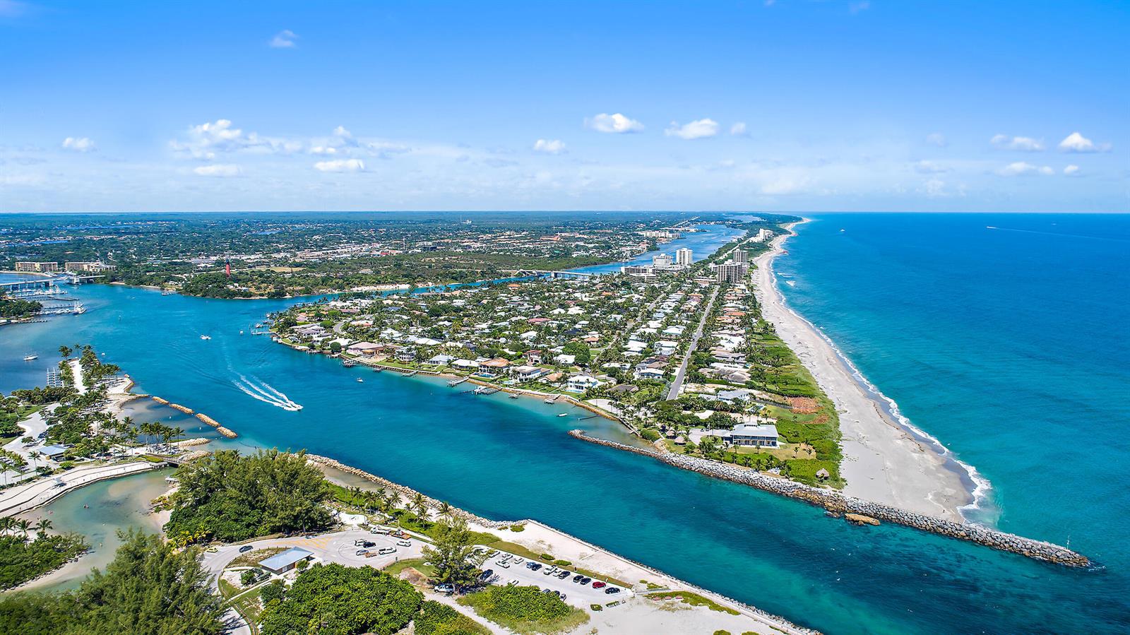 An aerial view shows a coastal inlet with a beach, residential homes, and a lighthouse — 1300 S Highway A1a # 523, Jupiter FL 33477, JUPITER, FL