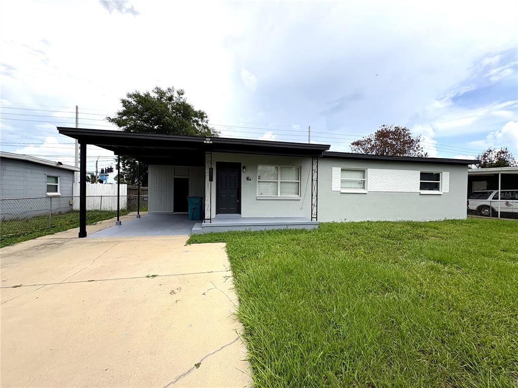 A single-story house with a gray exterior, a carport, and a front lawn — 821 S SOLANDRA DRIVE, ORLANDO, FL