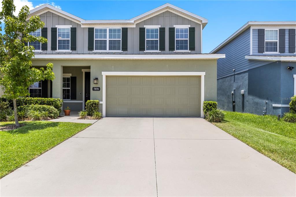 A two-story house with a green stucco facade, gray siding, and a two-car garage — 7878 GREENWAY AVENUE, WESLEY CHAPEL, FL