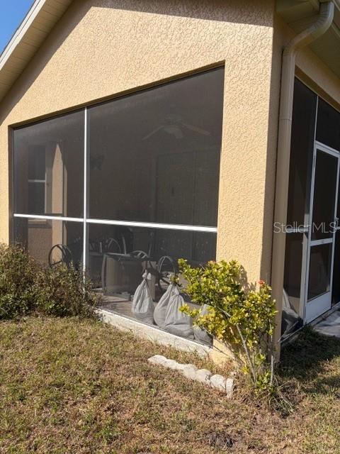A screened-in patio area is visible on the side of a beige stucco house — 7536 BERNA LANE, LAND O LAKES, FL
