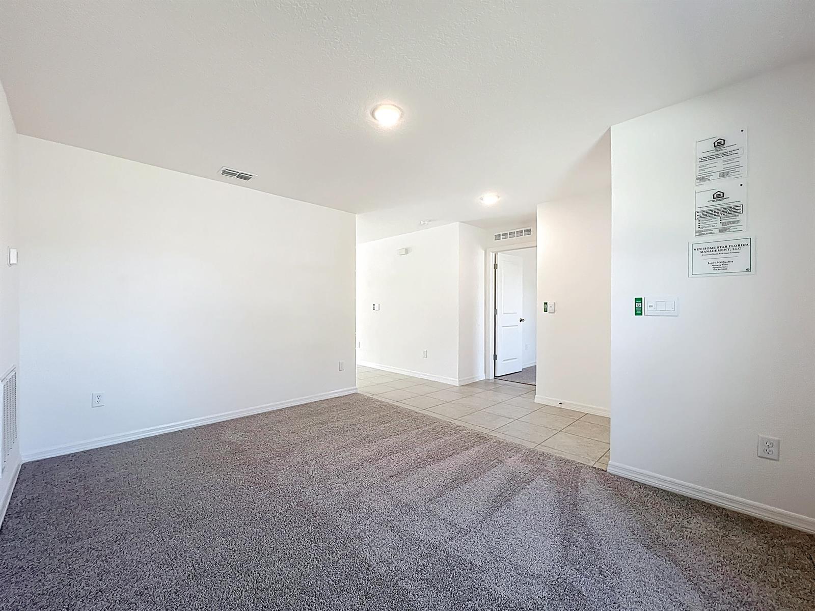 An interior room features gray carpet, white walls, recessed lighting, and a tiled entryway — 1390 Schumann Drive, Sebastian FL 32958, SEBASTIAN, FL