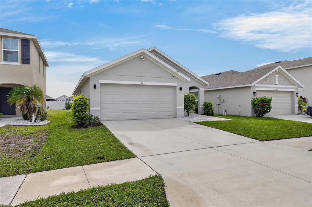 A single-story suburban house with a gray exterior, a two-car garage, and a concrete driveway — 579 OLIVE CONCH STREET, RUSKIN, FL