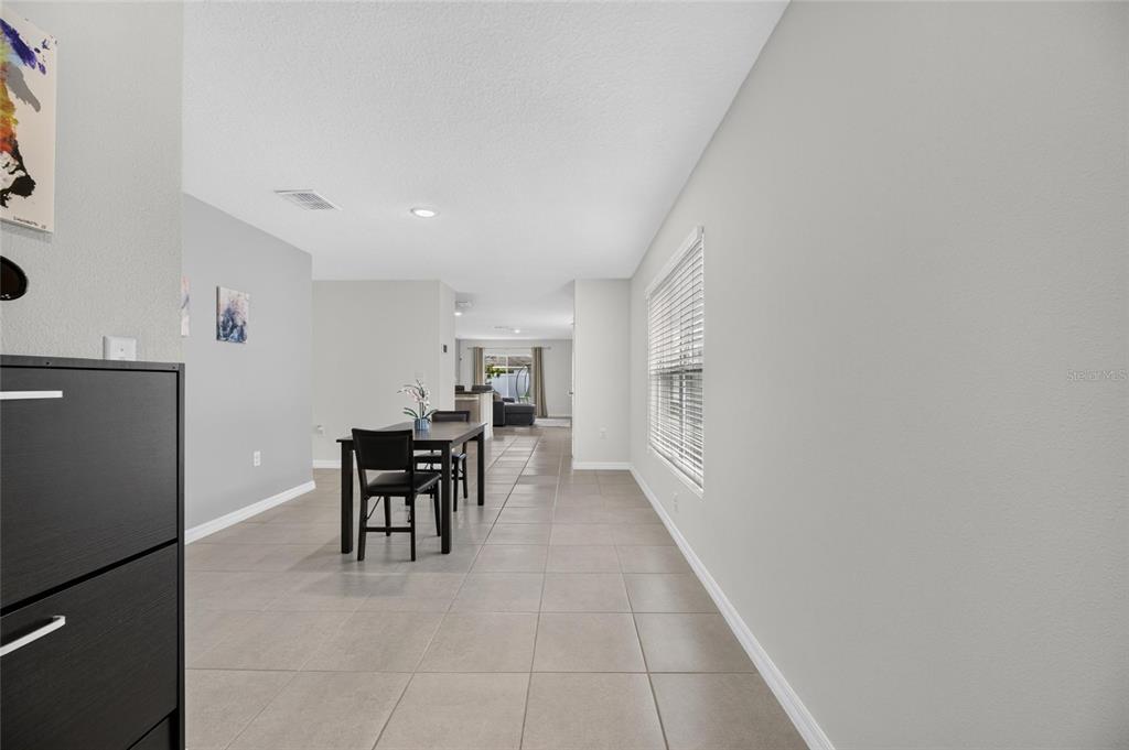 A dining area with tile flooring, a dark wood table, and light gray walls — 579 OLIVE CONCH STREET, RUSKIN, FL