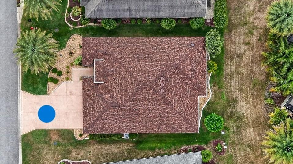 An aerial view shows a house with a brown shingled roof and a concrete driveway — 1294 ALLAIRE LOOP, THE VILLAGES, FL
