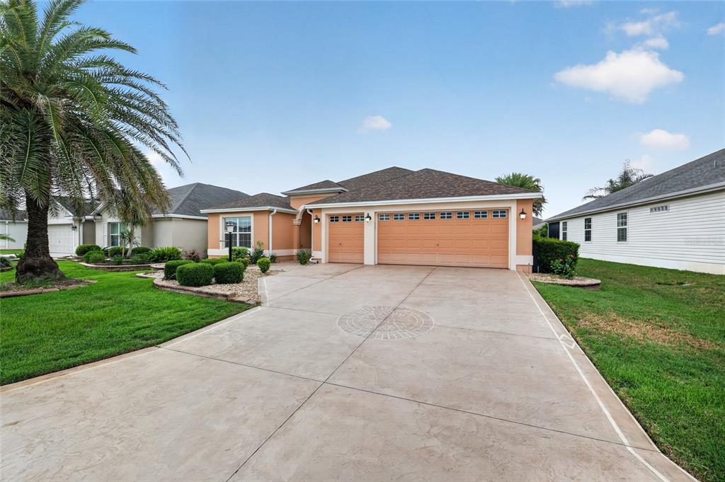A single-story house with a three-car garage and a decorative concrete driveway — 1294 ALLAIRE LOOP, THE VILLAGES, FL