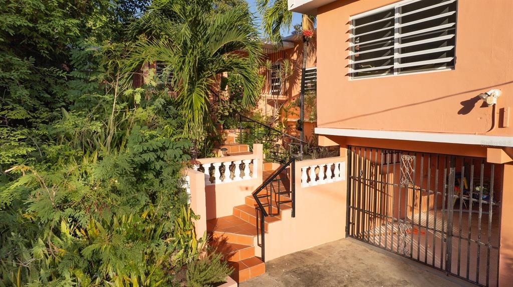An exterior view of an orange house with a gated garage and tiled stairs — 993 CALLE 16, VIEQUES, PR