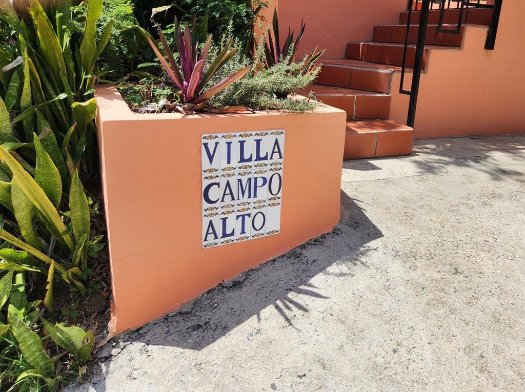 A sign reading Villa Campo Alto is mounted on a peach-colored planter near outdoor stairs — 993 CALLE 16, VIEQUES, PR