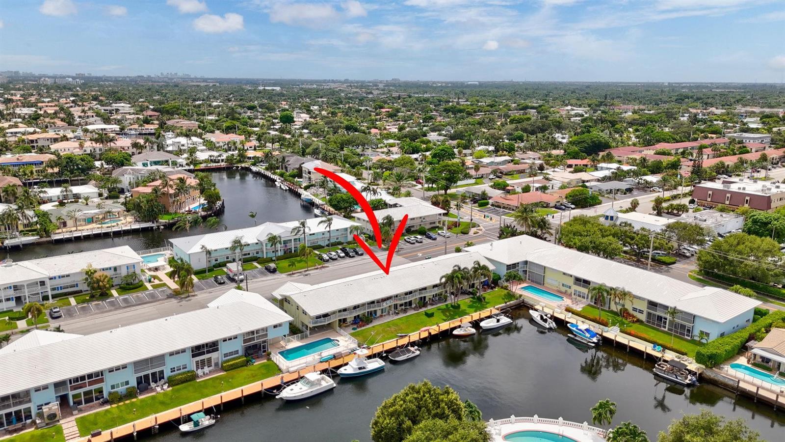 An aerial view shows a multi-story apartment complex with a canal, boat slips, and pools — 2311 NE 36th Street # 1f, Lighthouse Point FL 33064, LIGHTHOUSE POINT, FL