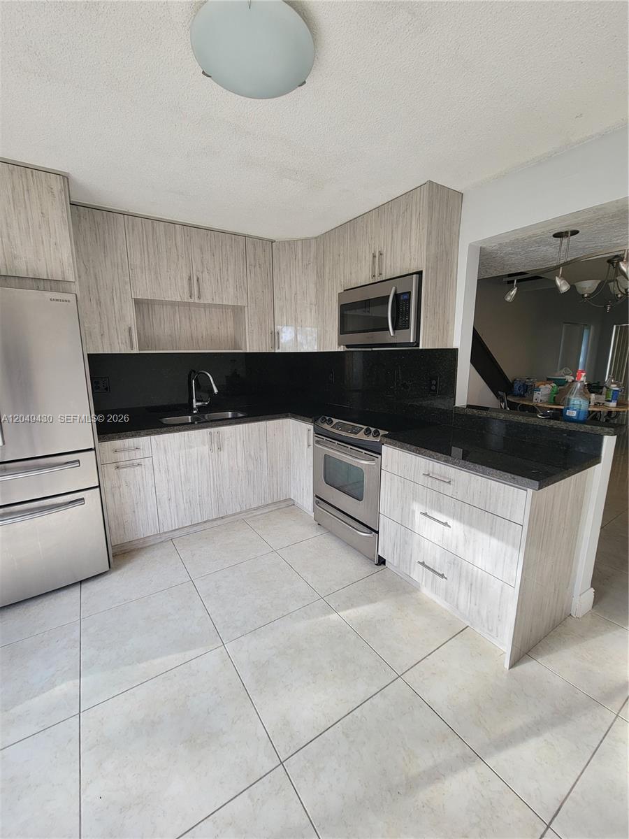 A concrete walkway leads through a grassy yard between a house and a wooden fence — 3504 NW 111th Ave # 3504, Sunrise FL 33351, SUNRISE, FL