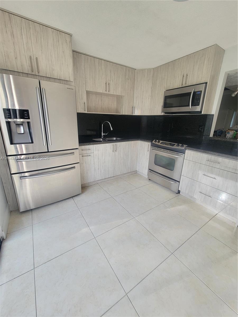 A concrete patio extends from the side of a house toward a fenced grassy yard — 3504 NW 111th Ave # 3504, Sunrise FL 33351, SUNRISE, FL