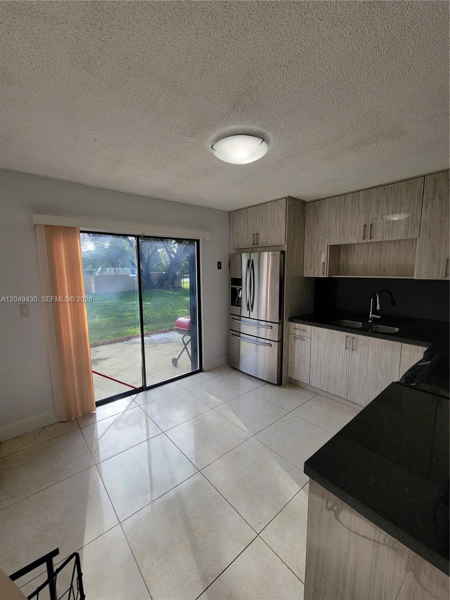 The exterior of a two-story townhouse features a concrete patio and a grassy lawn — 3504 NW 111th Ave # 3504, Sunrise FL 33351, SUNRISE, FL