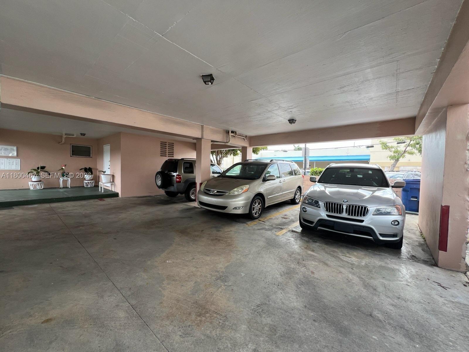 A covered parking area features concrete flooring and three parked vehicles — 7125 Dickens Ave # 4, Miami Beach FL 33141, MIAMI BEACH, FL