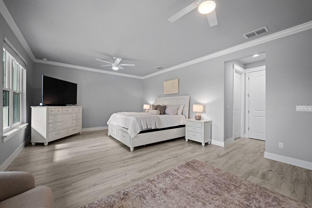 A kitchen with gray cabinets and a marble countertop overlooks an open-concept living area — 590 LAKE WINNEMISSETT DRIVE, DELAND, FL