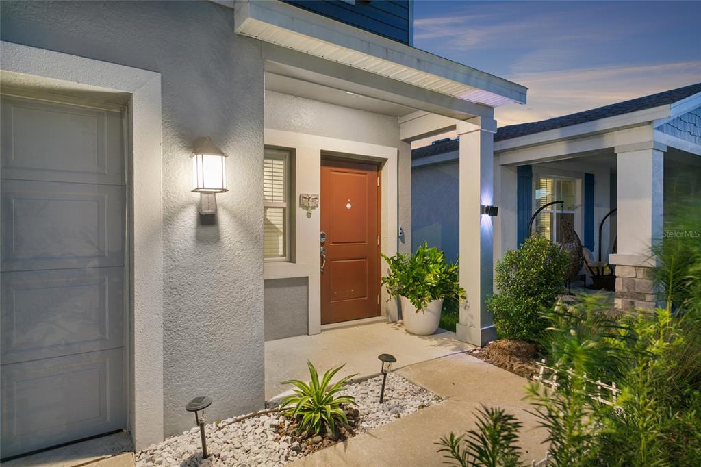 A front exterior view of a house featuring a brown door and a covered porch — 1418 AUSTIN STREET, WINTER HAVEN, FL