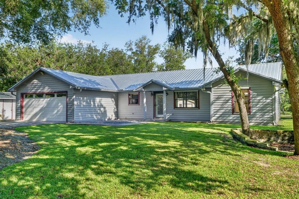 A single-story house with gray horizontal siding, a metal roof, and a two-car garage — 171 WILLIAM STREET, EDGEWATER, FL