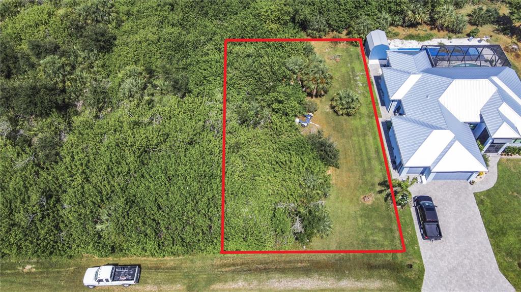 An aerial view shows a rectangular vacant lot outlined in red next to a house — 15707 MARGO CIRCLE, PORT CHARLOTTE, FL
