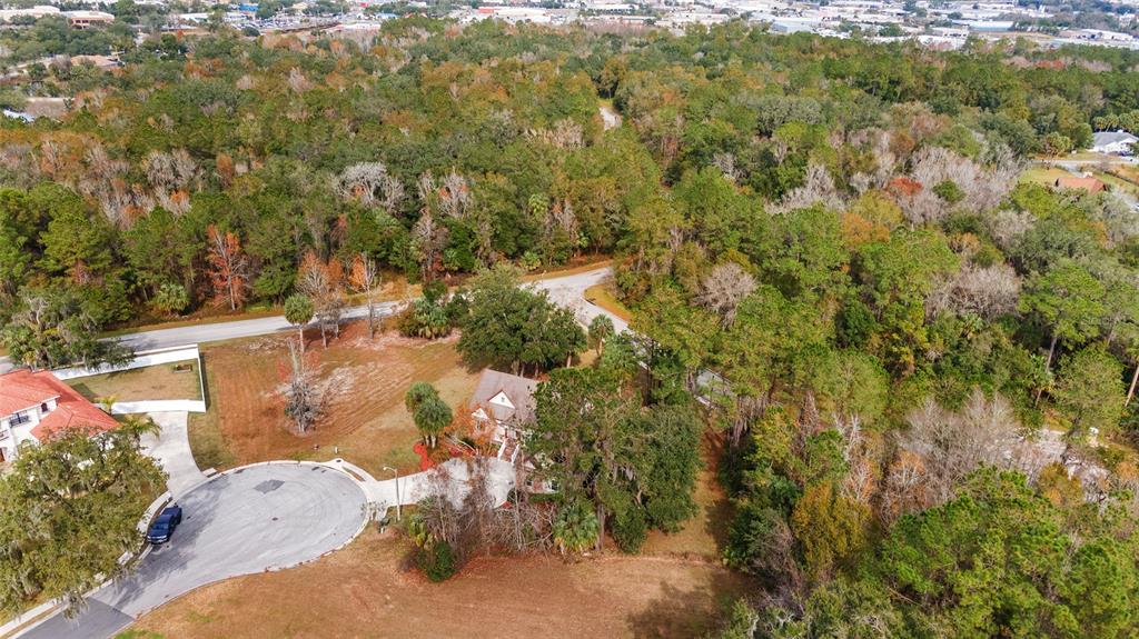 An aerial view shows a house situated on a wooded lot near a cul-de-sac — 1706 SW 27TH STREET, OCALA, FL
