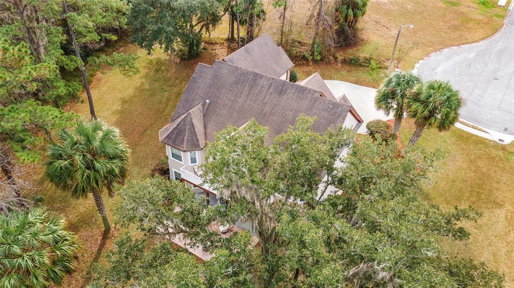 An aerial view shows a multi-story house with a shingled roof surrounded by trees — 1706 SW 27TH STREET, OCALA, FL